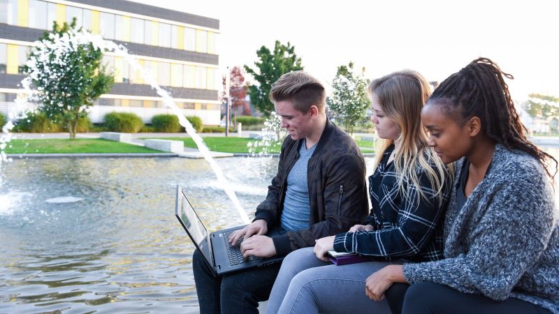 Menschen schauen auf einen Laptop 