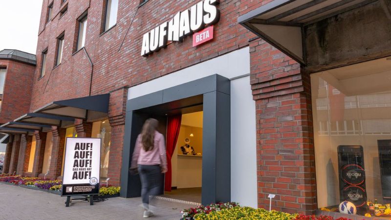 Auf dem Bild sieht man eine Frau, die den begehbaren Online-Marktplatz aufHaus betritt.