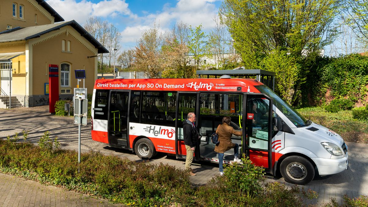 Menschen die in einen On-Demand Bus einsteigen. 